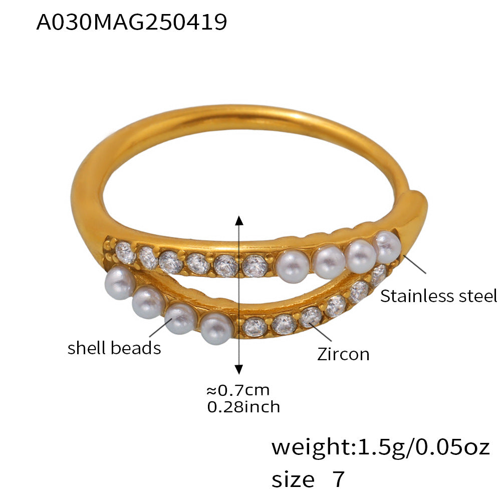 Stylish gold stainless steel pearl ring with zirconia on textured background