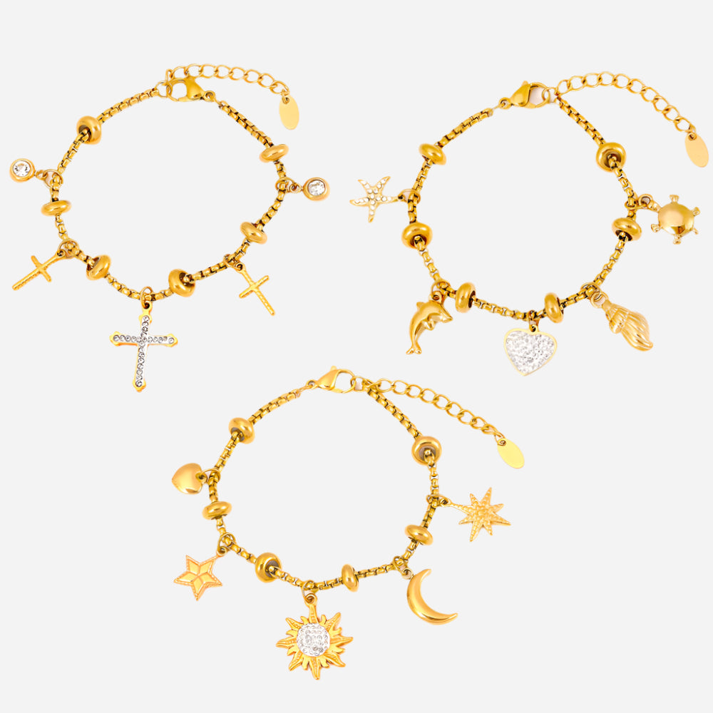 Set of three gold anklets with dainty stainless steel charms on a white background