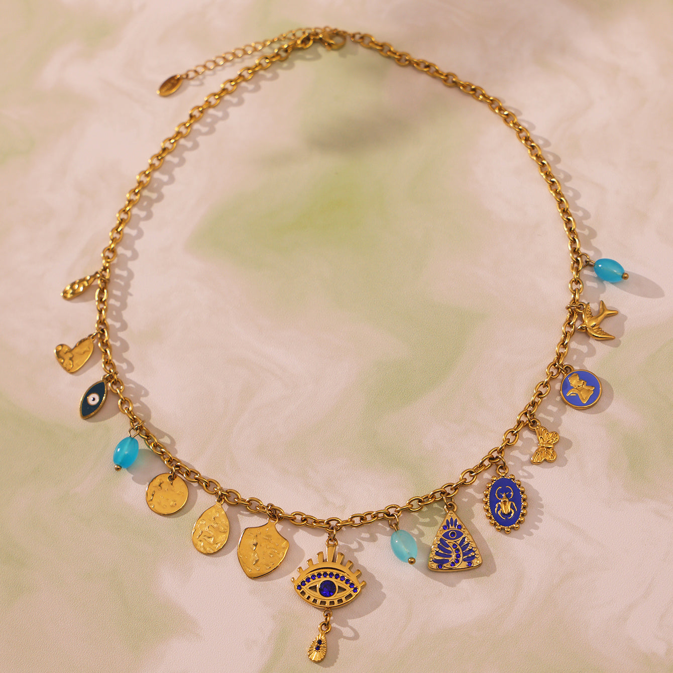 Yellow evil eye bracelet styled on a sandy surface with summer props like sunglasses and seashells