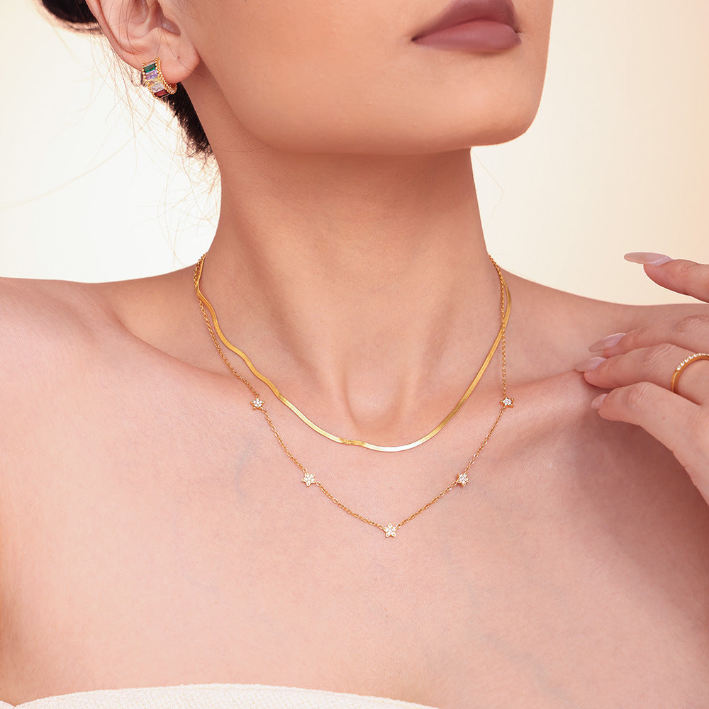 Model layering five-pointed star tennis necklace with gold minimalist chain – side view