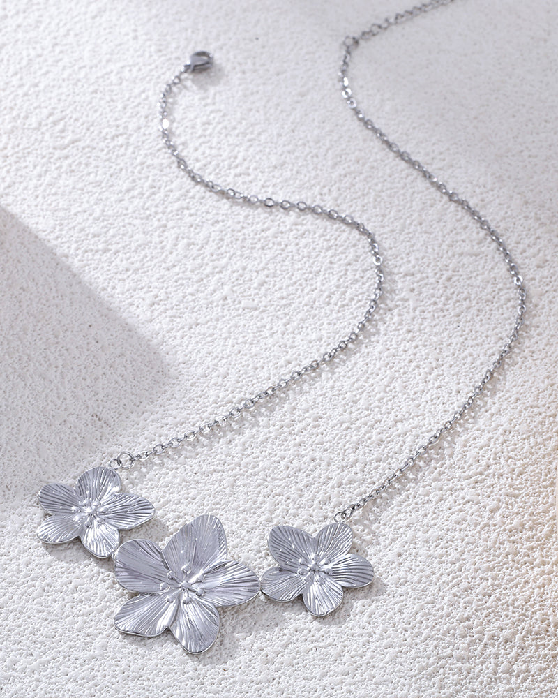 Stainless steel floral necklace displayed with soft light