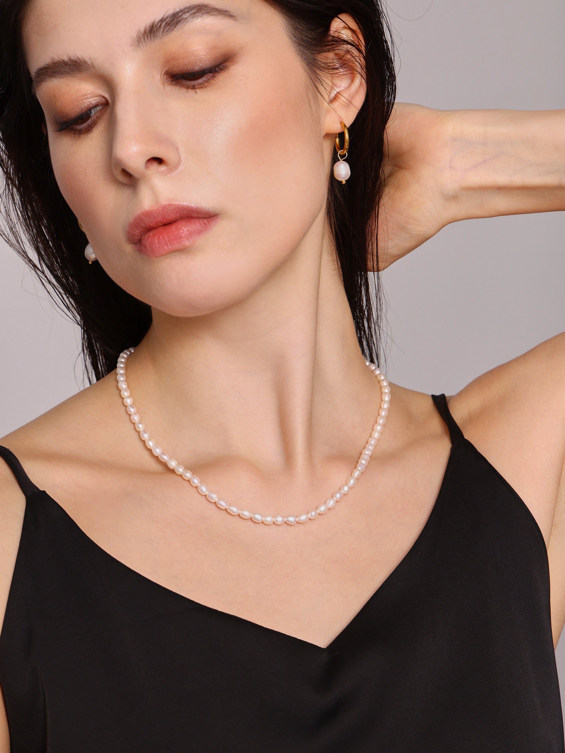Model Holding Necklace While Wearing Baroque Pearl Choker – Artistic Pose