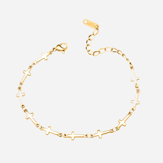 Gold bracelet with star and cross designs on a white background