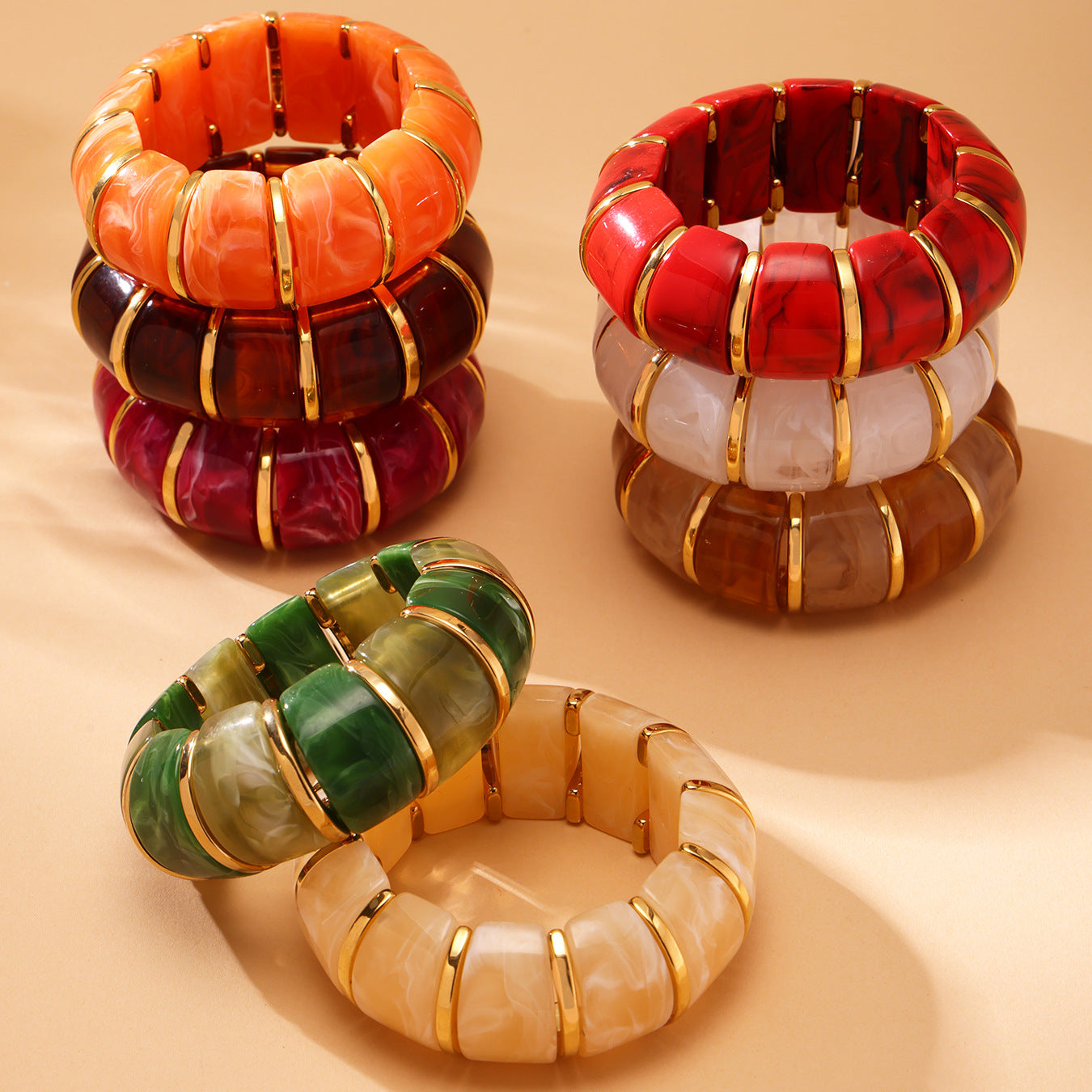 Set of colorful bangles with gold accents on a beige background