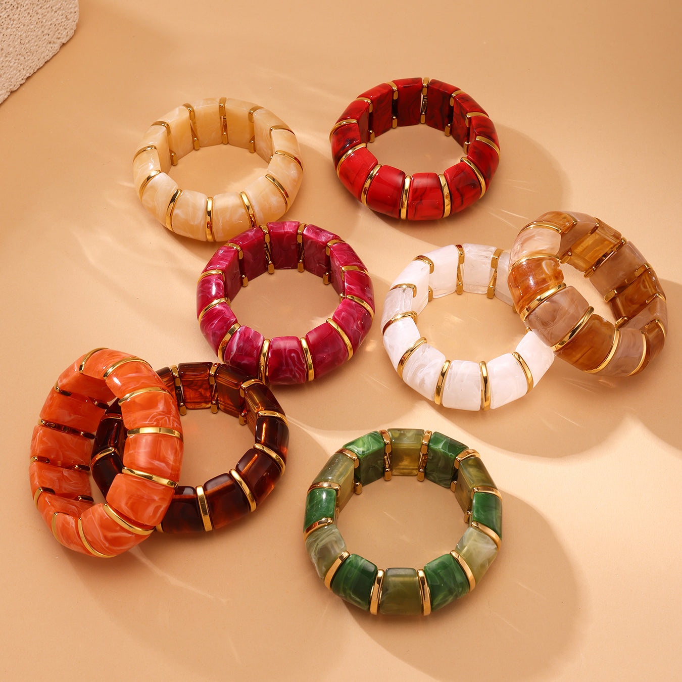 Set of colorful beaded bracelets on a beige surface