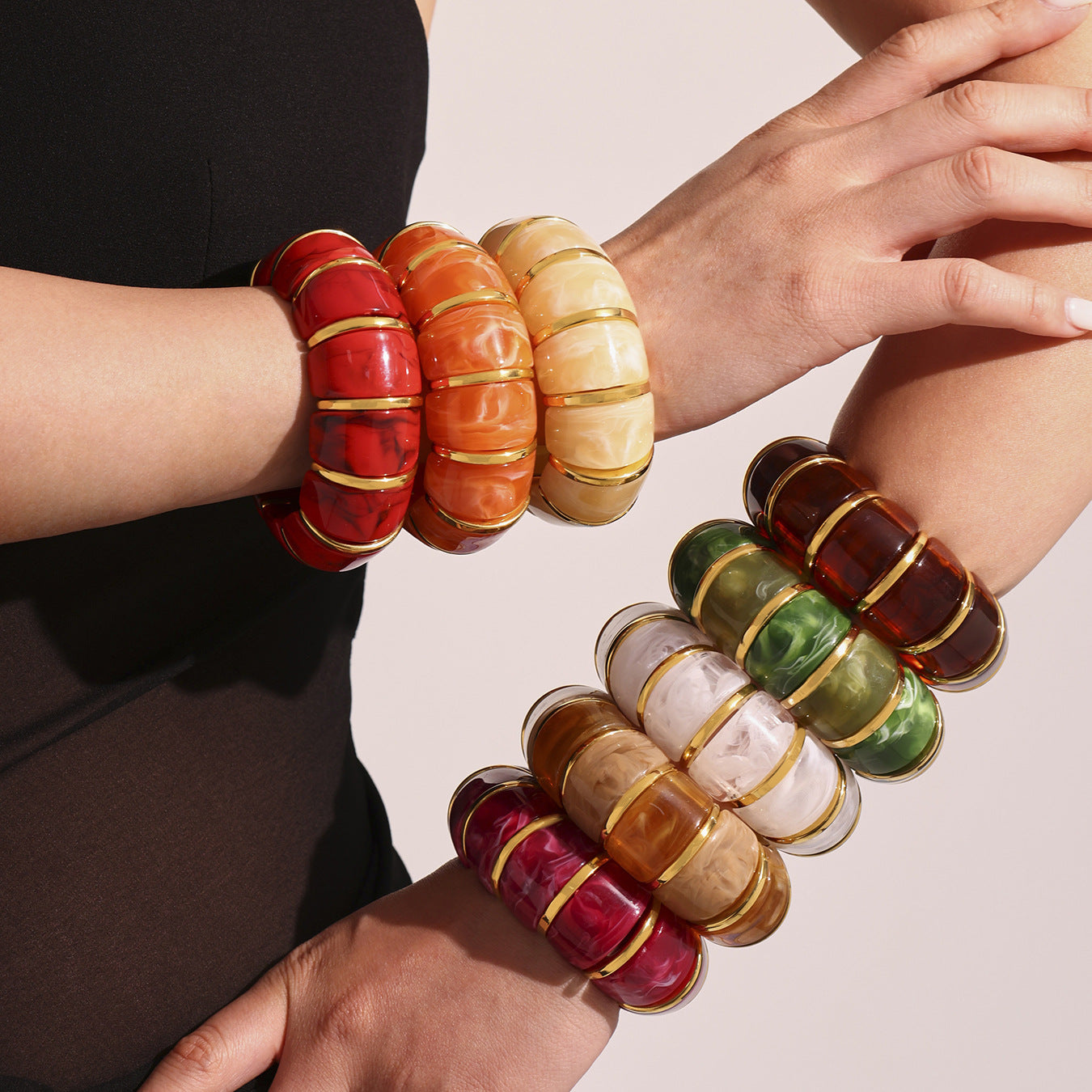 Colorful beaded bracelets on wrists with a neutral background