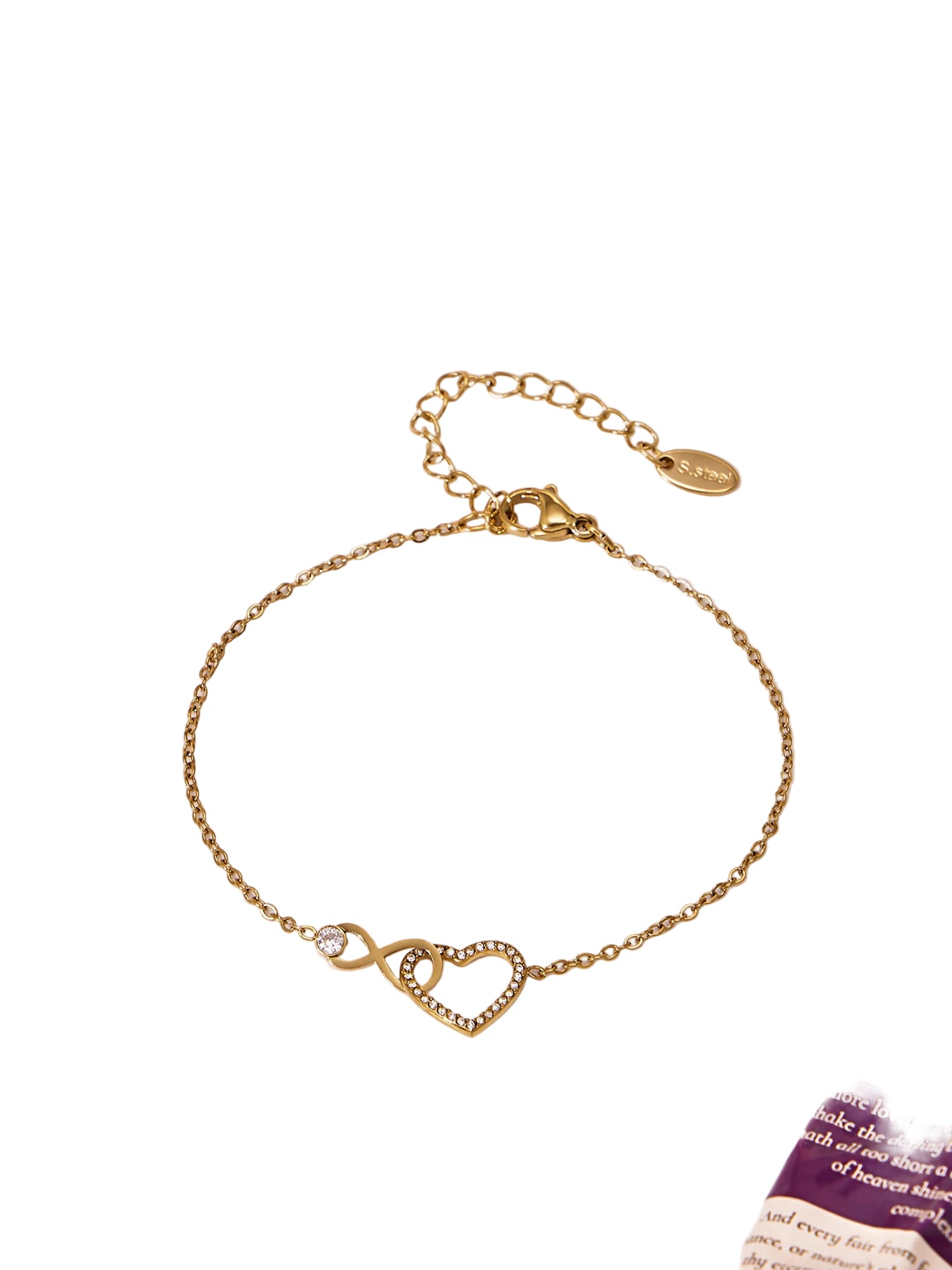 Gold bracelet with heart and infinity symbol on a white background