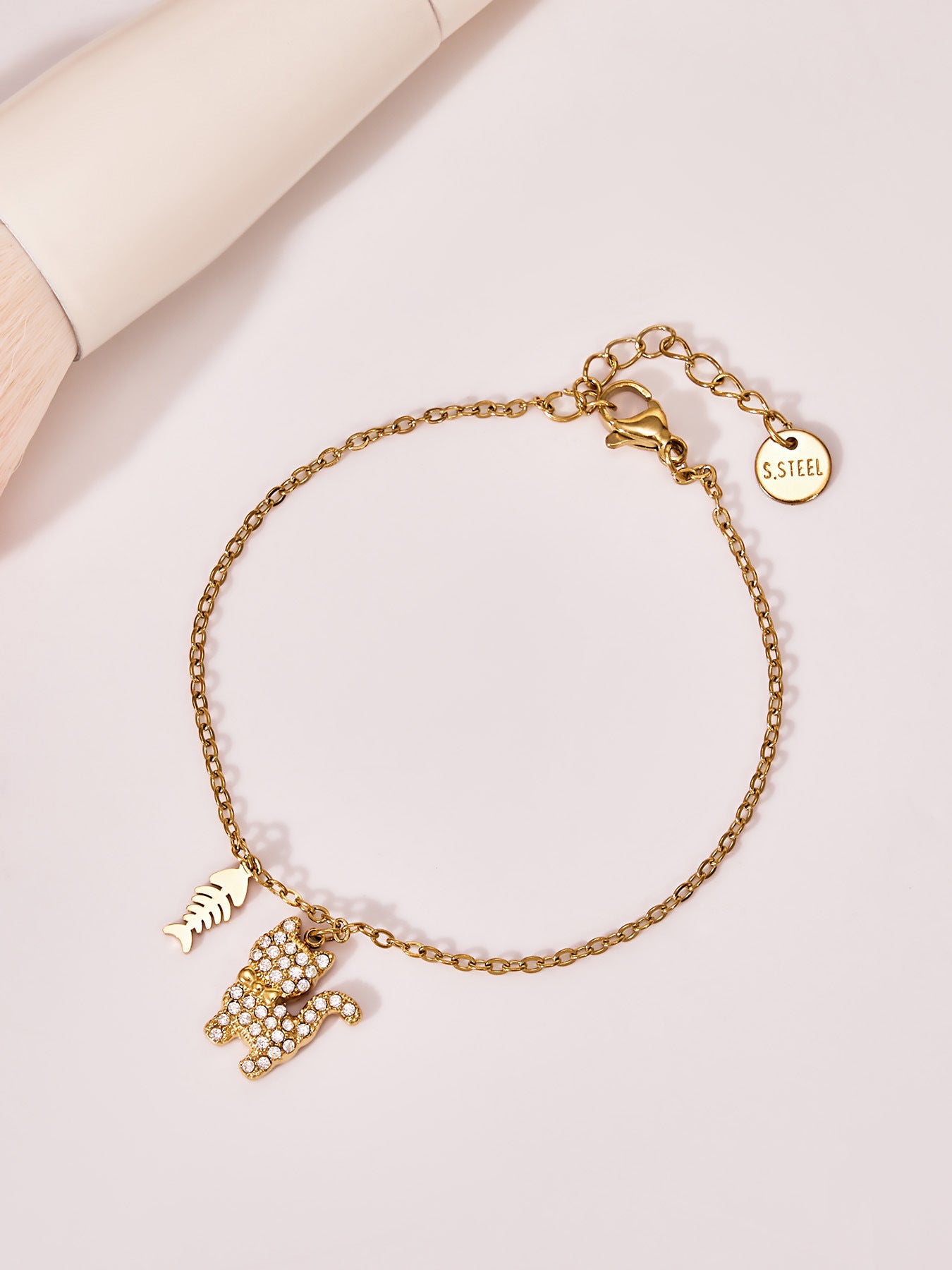 Close-up of the gold cat bracelet in soft lighting highlighting the CZ stones and delicate chain.