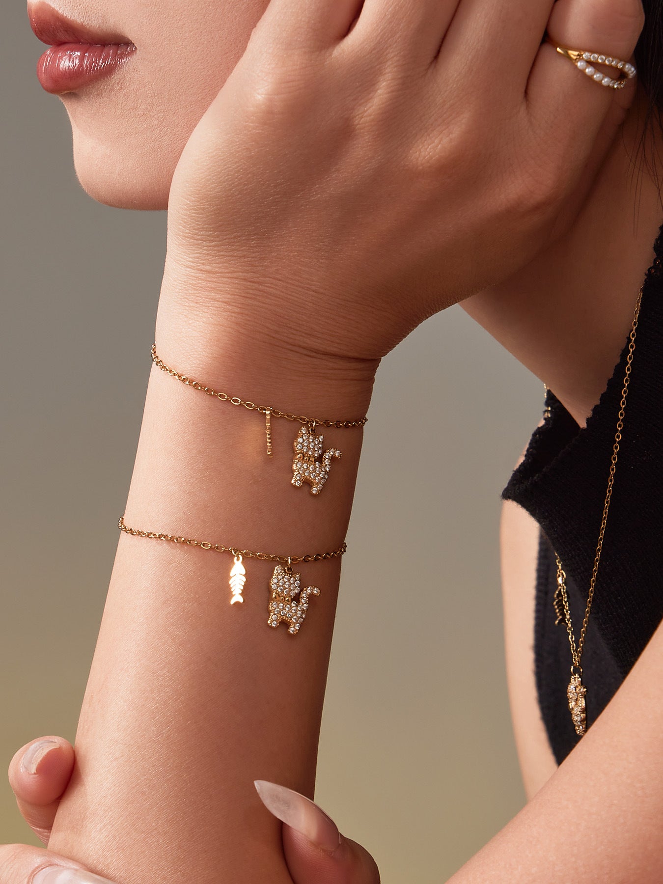 Model wearing the gold cat tennis bracelet, showing the sparkling CZ cat charm and minimalist chain.