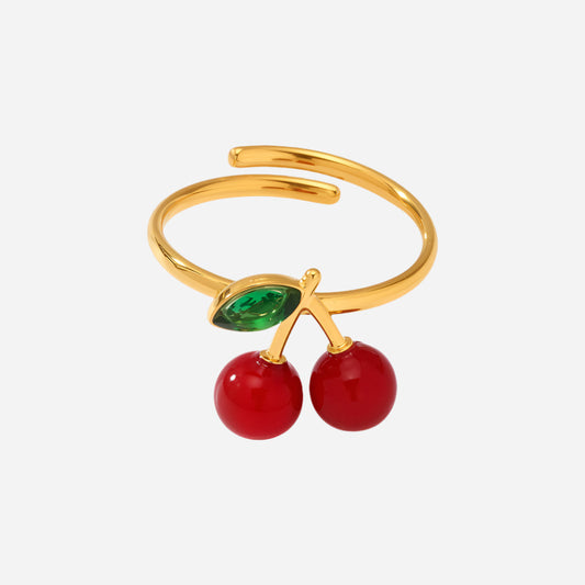 Gold sea glass ring with red resin cherries and green rhinestone on white background