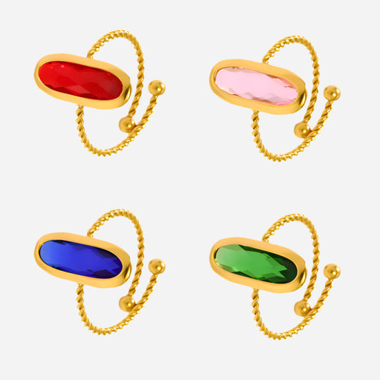 Stackable gold sea glass rings with colorful gemstones arranged on a white background