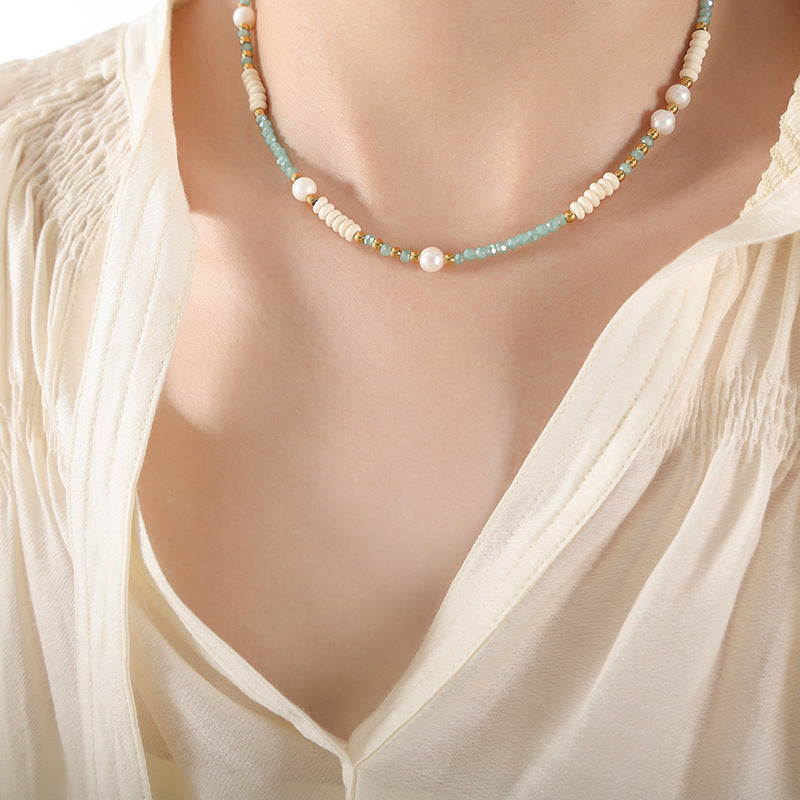 Close-up of pearl and glass bead necklace on model