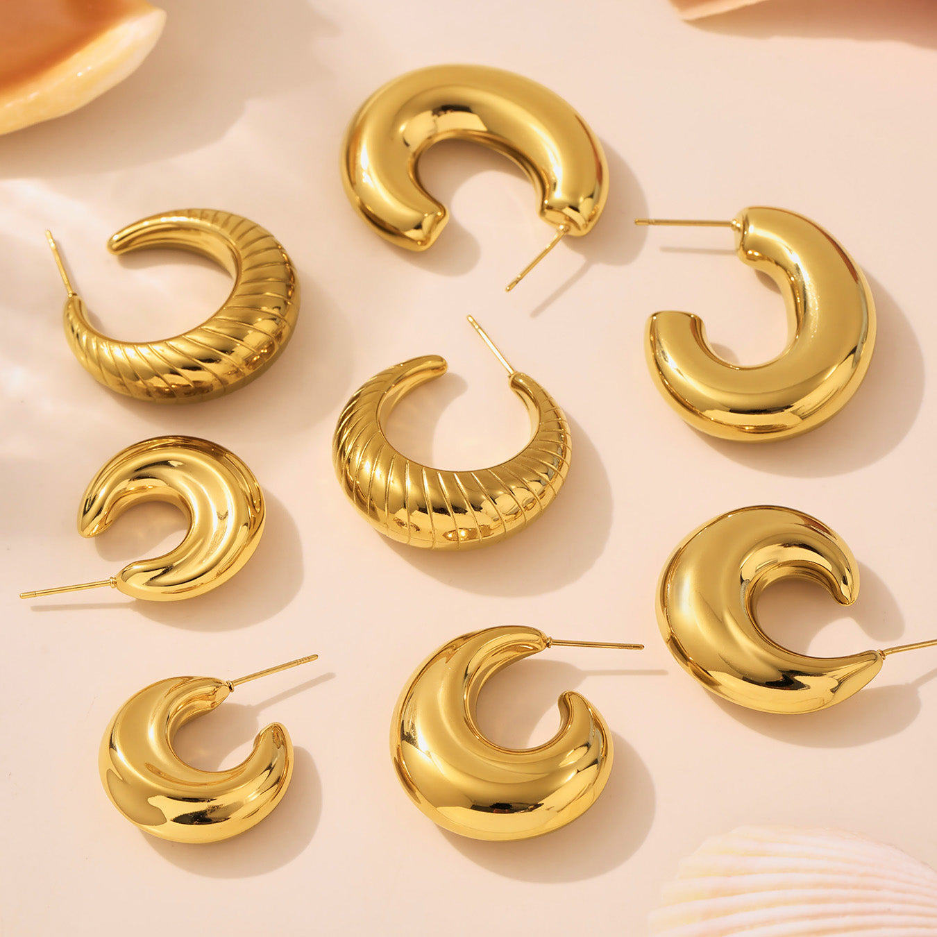 Gold hoop earrings on a beige background