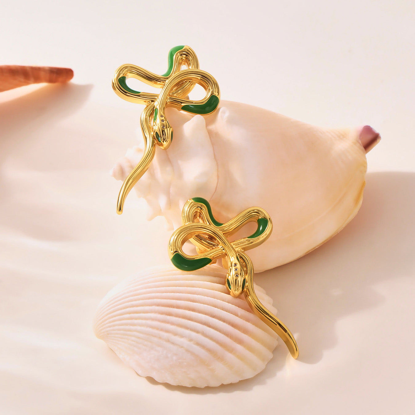 Gold and green brooch on a seashell with a soft focus background