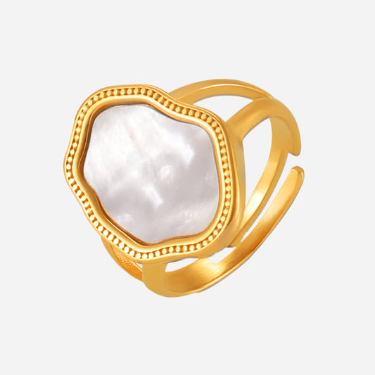Gold-plated mother of pearl ring on light gray background – minimalist seashell design