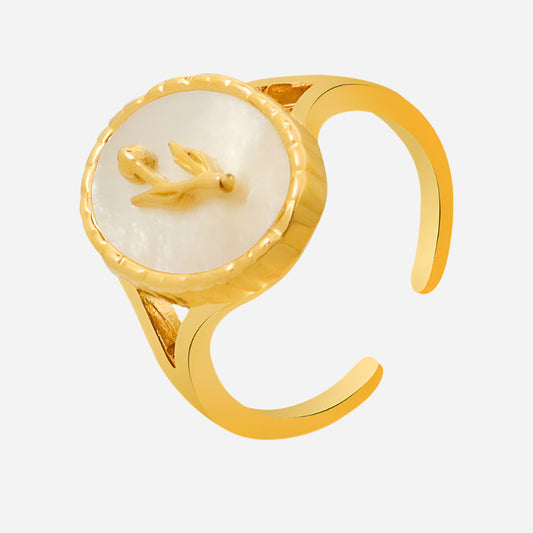 Gold pearl-style ring with white stone and bird design, displayed on light gray background