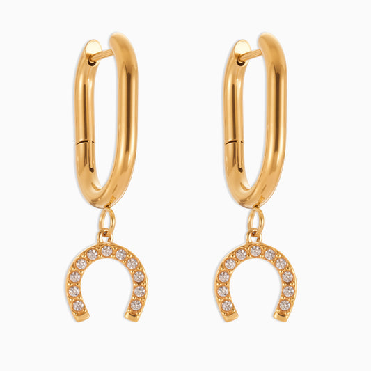 Gold hoop earrings with horseshoe charms on a white background