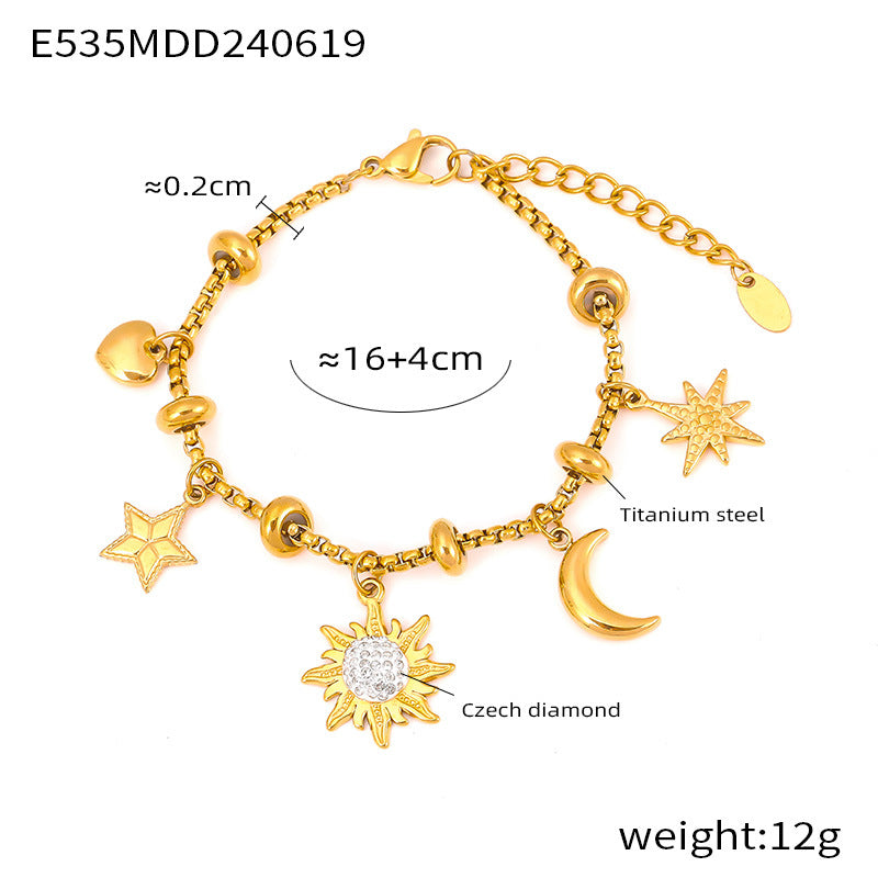 Celestial-themed gold charm bracelet with star, moon, and sun charms on white background