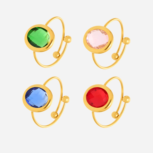 Four gold sea glass rings with colorful gemstones on white