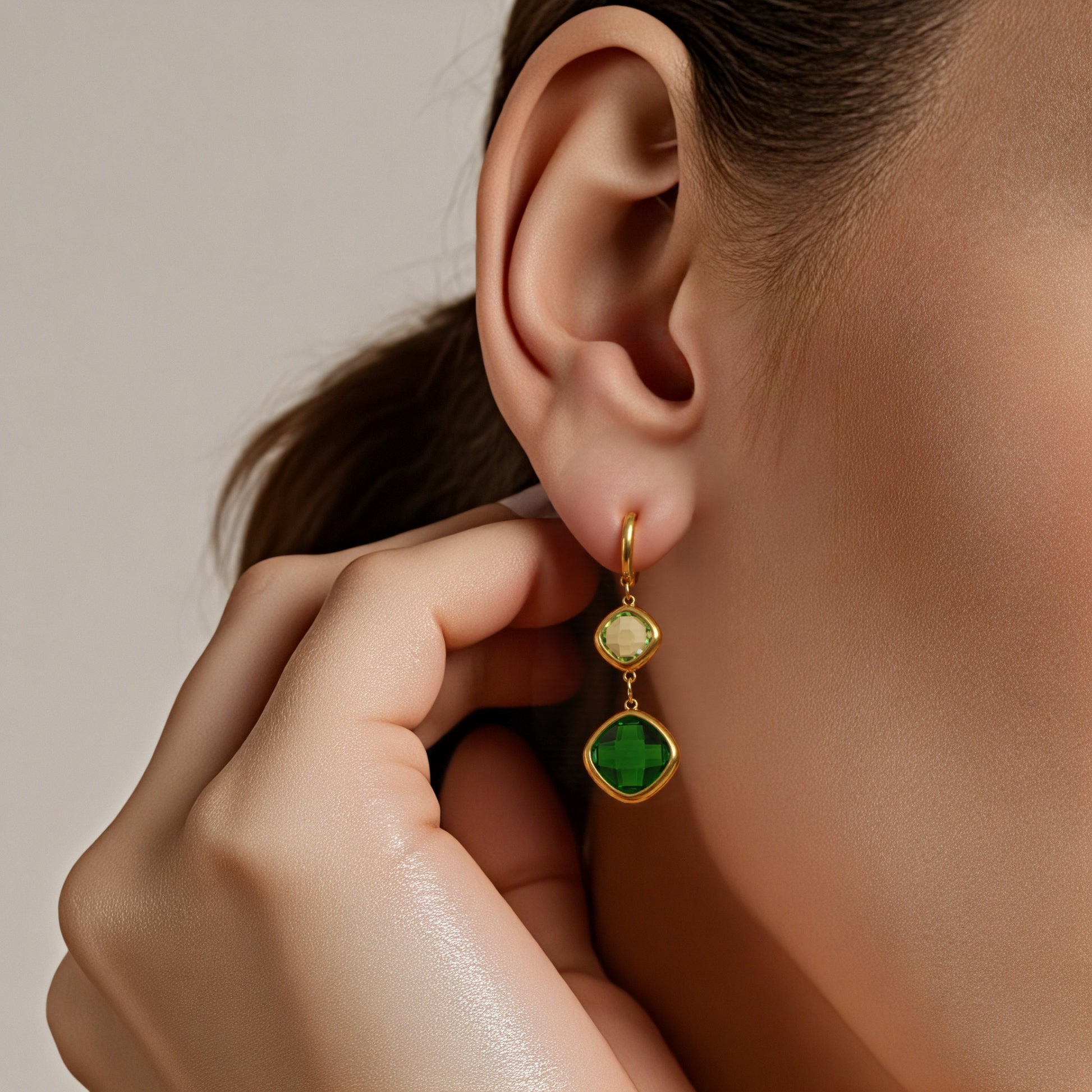 Model wearing green gemstone dangle earrings in gold, minimalist waterproof earrings for women
