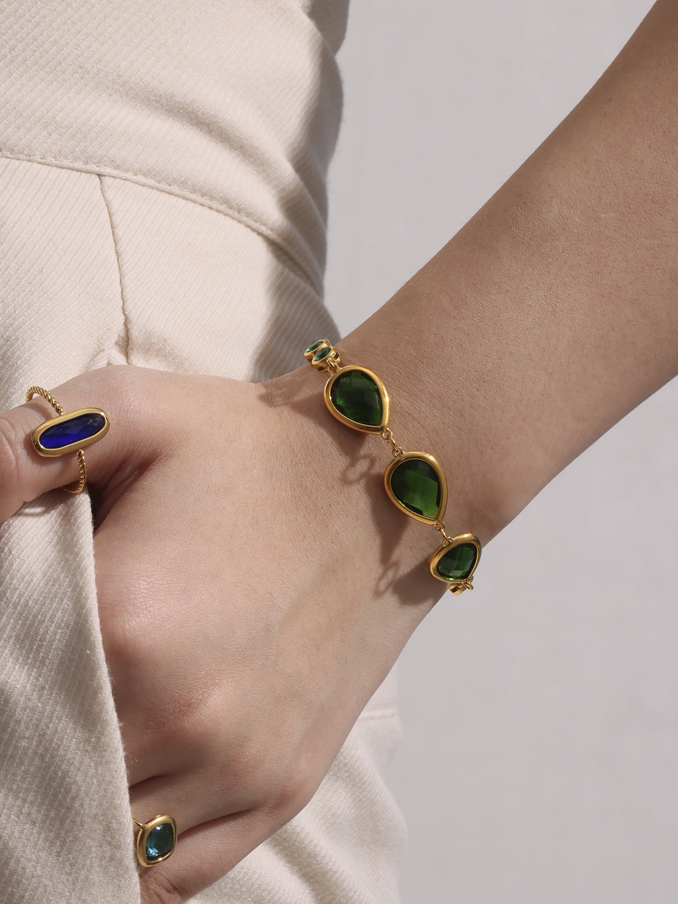 Green teardrop sea glass bracelet worn on wrist, gold stainless steel chain, lightweight and adjustable fit