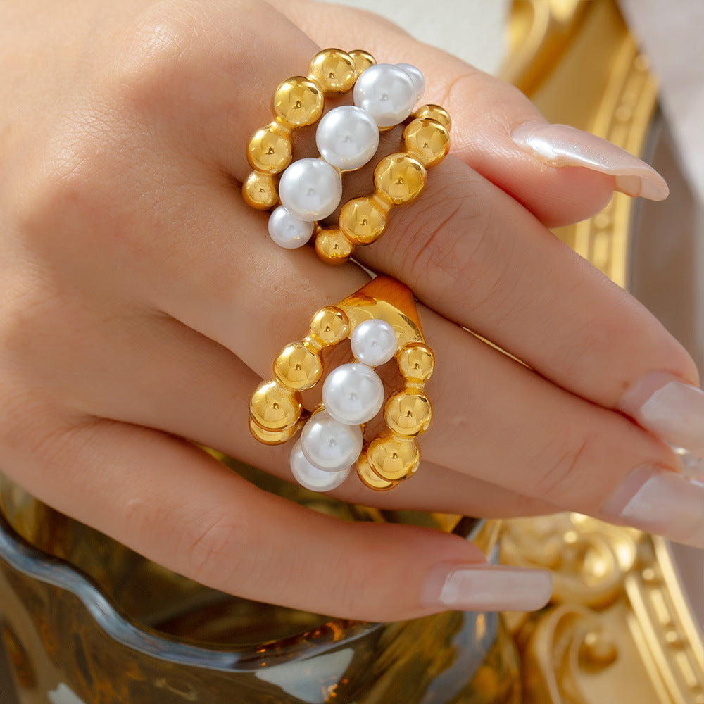  Hand wearing stacked gold rings with pearl beads – adjustable and waterproof statement jewelry