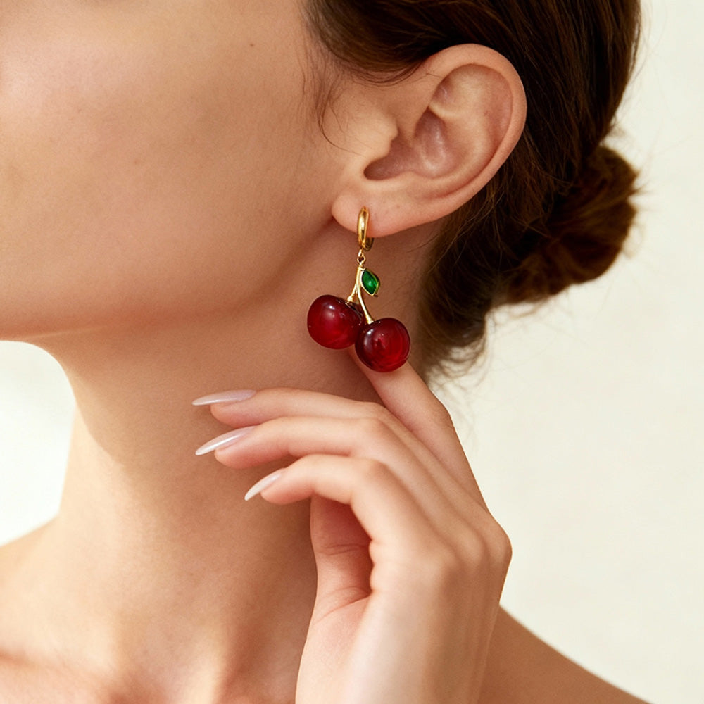 Model wearing gold cherry hoop earrings, playful feminine jewelry