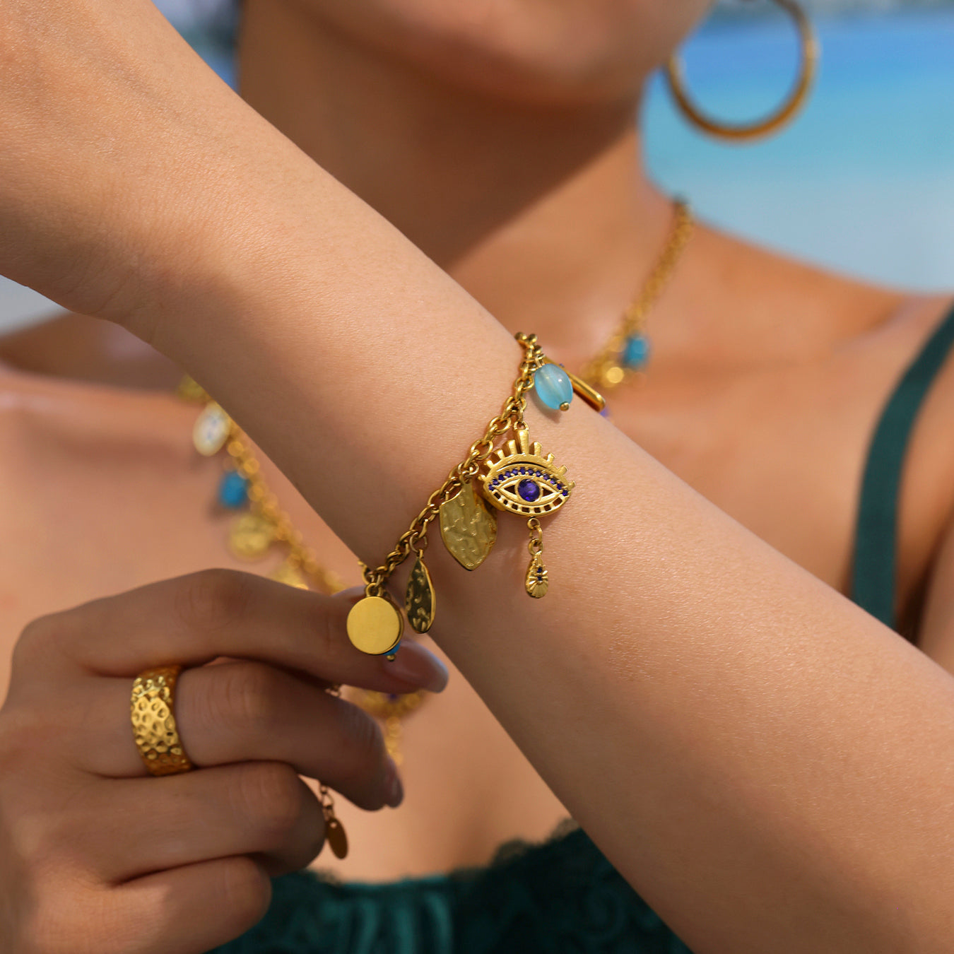 Female model wearing yellow stainless steel evil eye bracelet in an ocean breeze setting