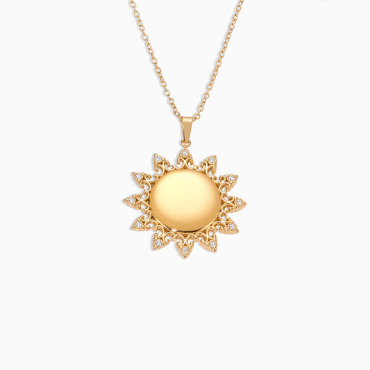 Gold sun-shaped pendant necklace on a white background