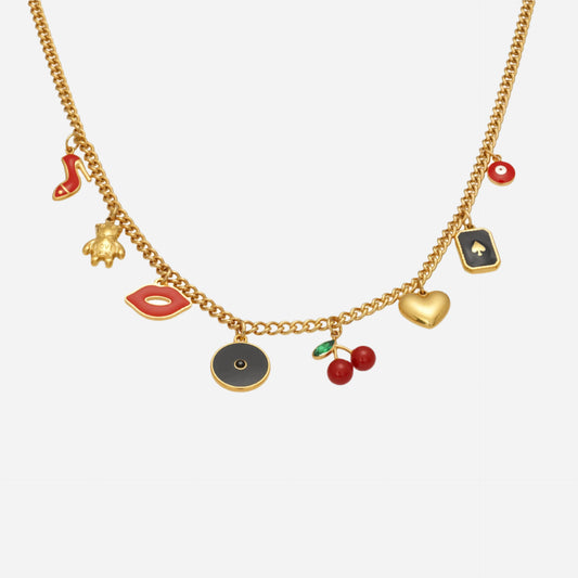 Vintage charm necklace with cherry, heart, dice, and lip enamel charms on gold chain, playful feminine jewelry flat lay