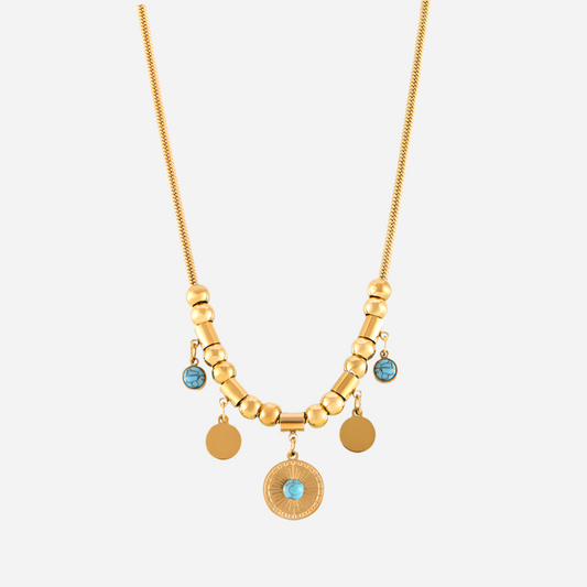 Gold necklace with blue gemstones on a white background