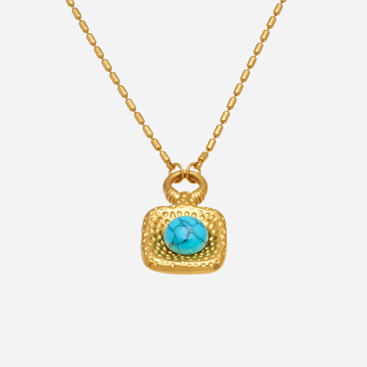Gold necklace with a turquoise pendant on a white background