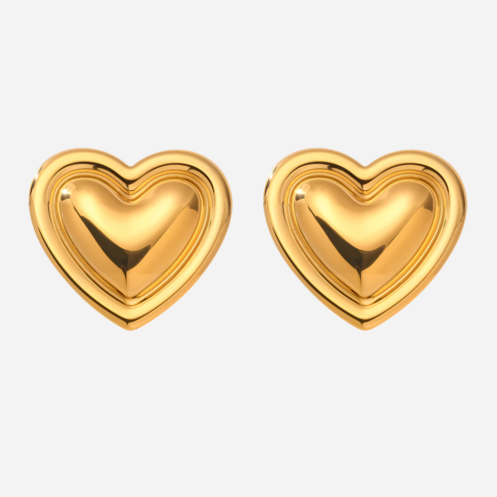 Pair of gold puffy heart stud earrings on a plain background