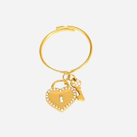 Gold keychain with heart and lock charm on a light gray background