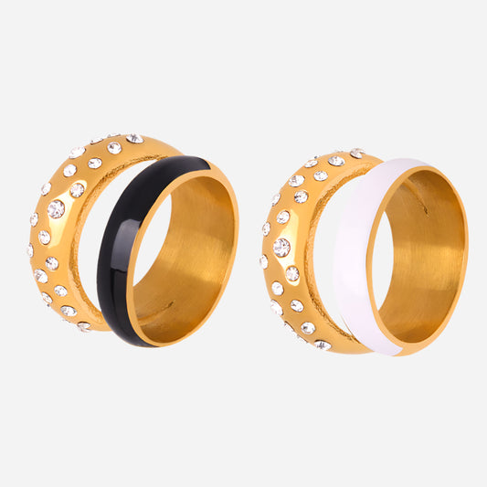 Two gold bangles with black and white accents on a white background