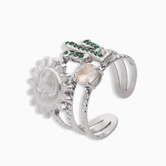 Silver chunky ring with sun design and gemstones, displayed on a light gray background.