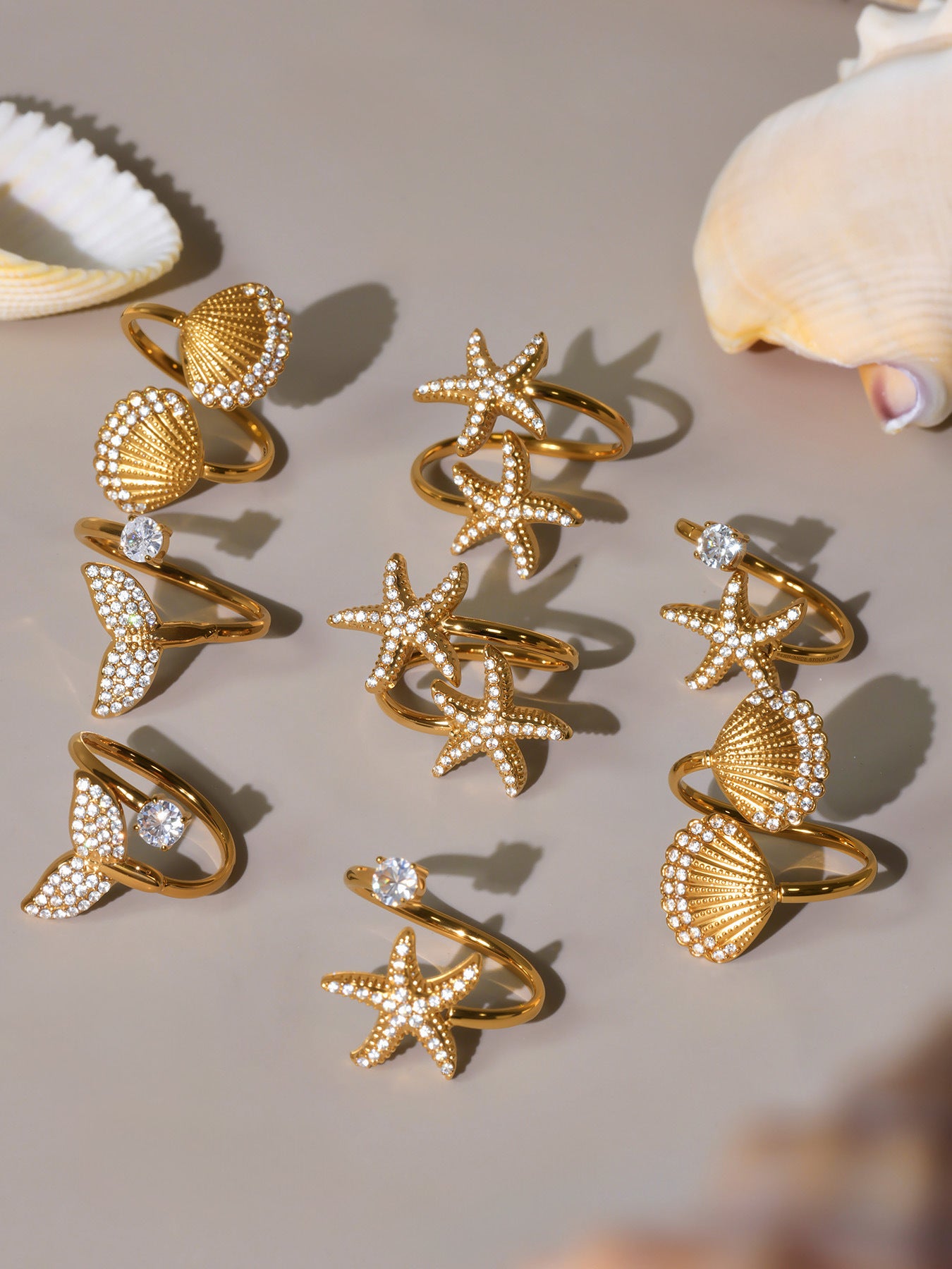Multiple gold starfish star rings and matching jewelry displayed together, ocean theme jewelry collection