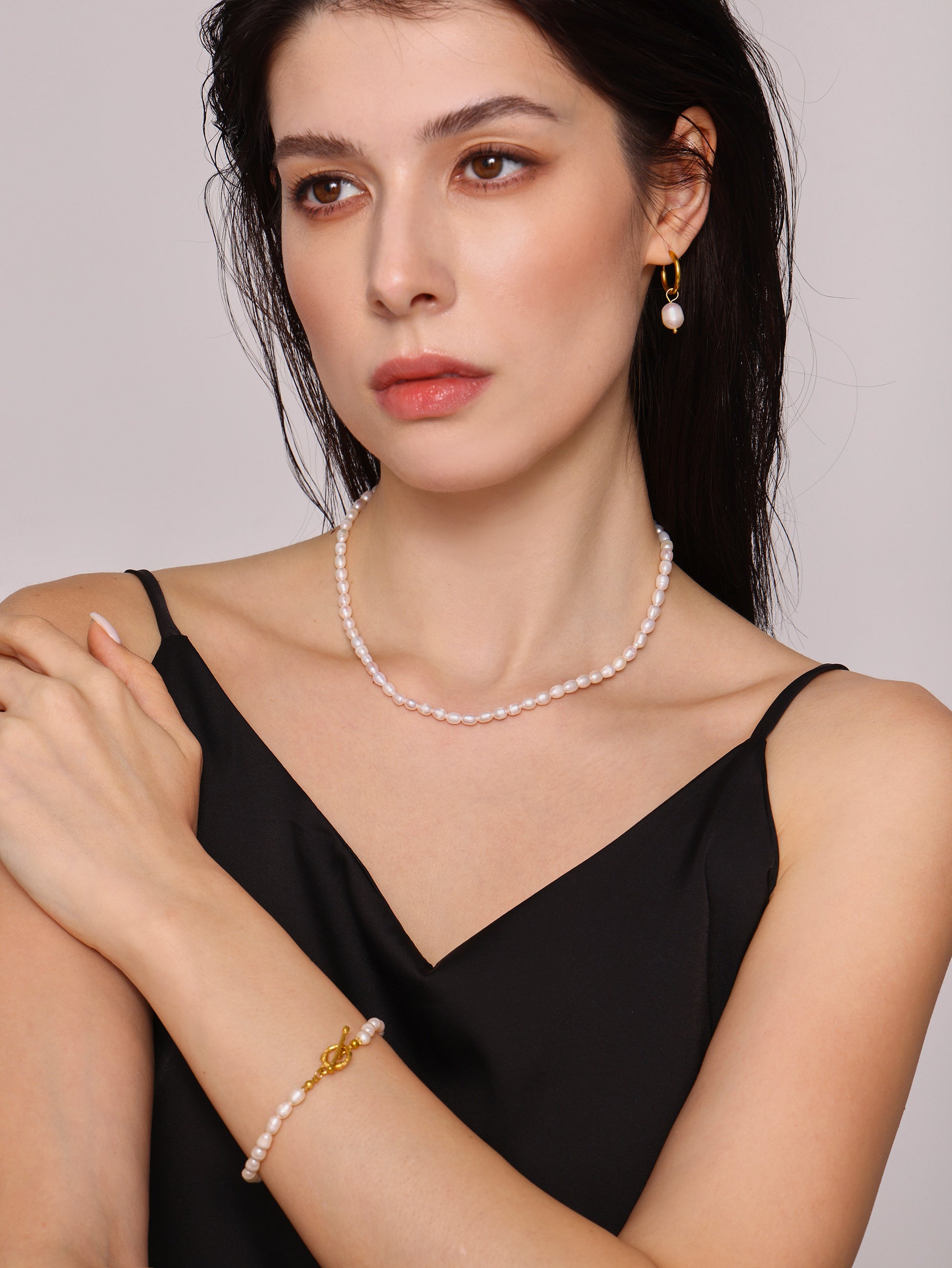 Model styling T-bar pearl bracelet with modern minimalist clothing