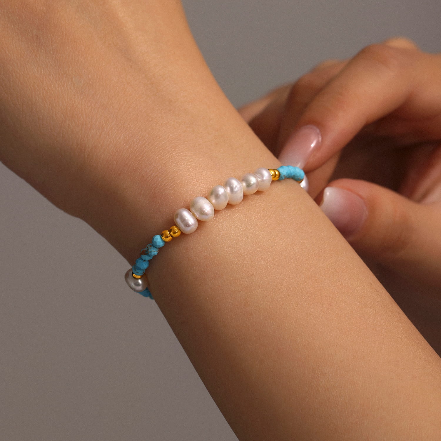 Woman wearing turquoise and pearl bracelet with casual summer outfit