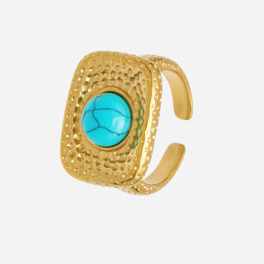 Gold ring with a turquoise stone on a white background