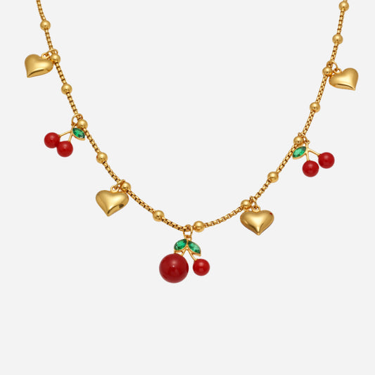 Gold necklace with heart and cherry pomegranate charms on a white background