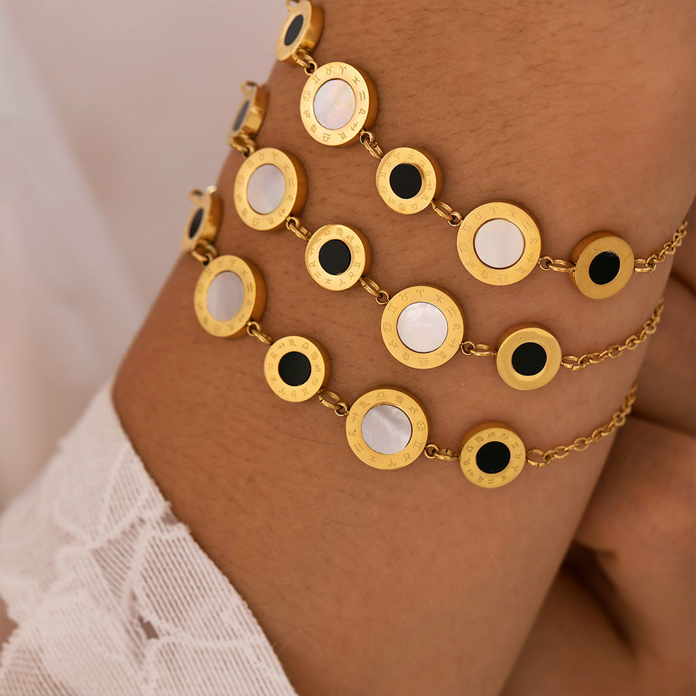 Gold tennis bracelet with circular designs worn on wrist against a neutral background