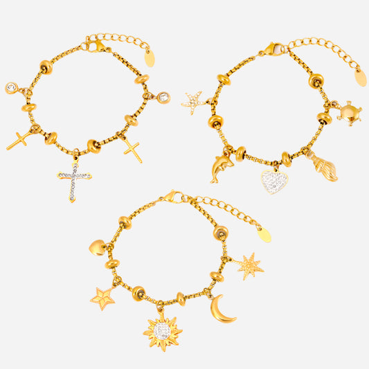 Set of three gold anklets with dainty stainless steel charms on a white background