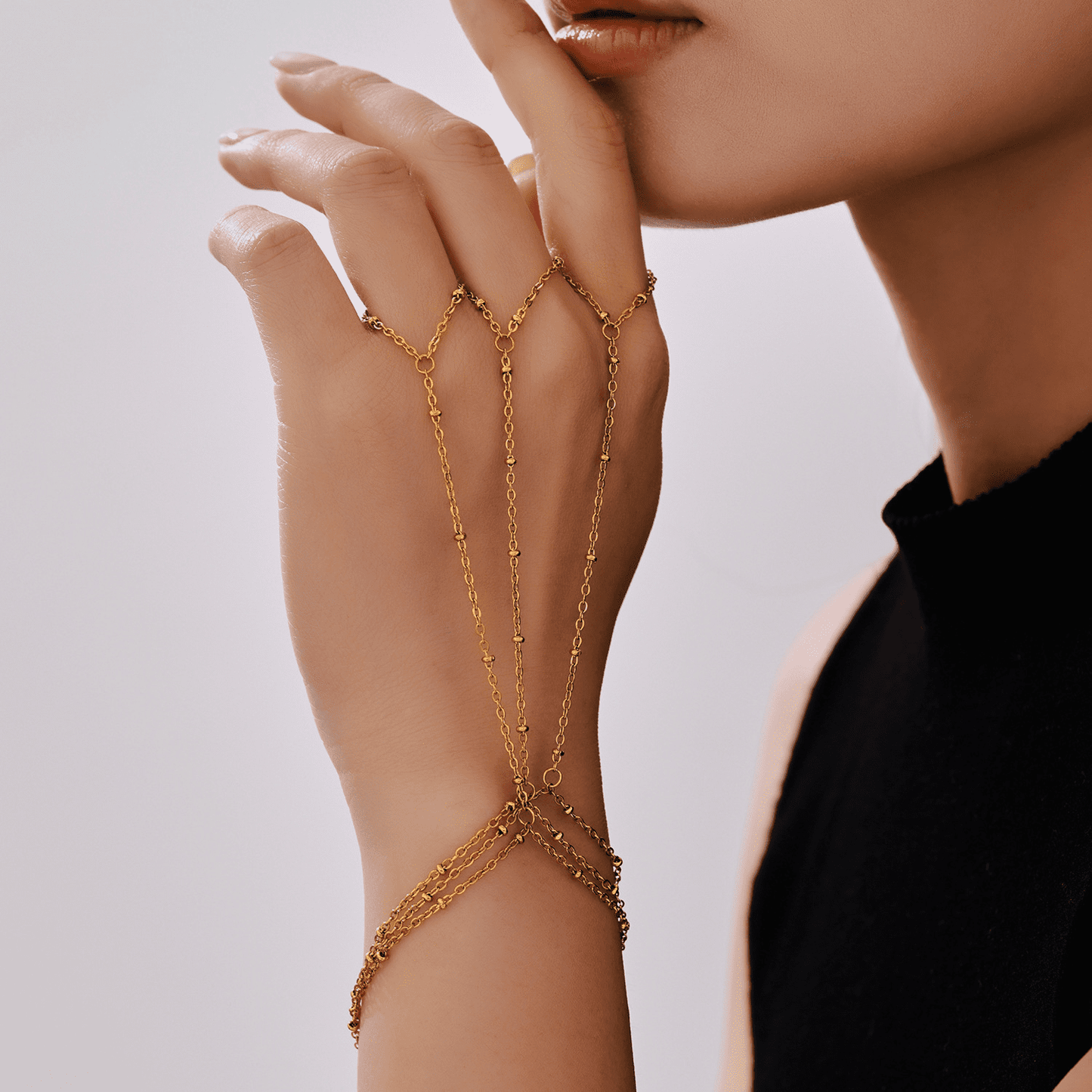 Woman wearing asymmetrical gold bead bracelet with street style outfit – stainless steel jewelry