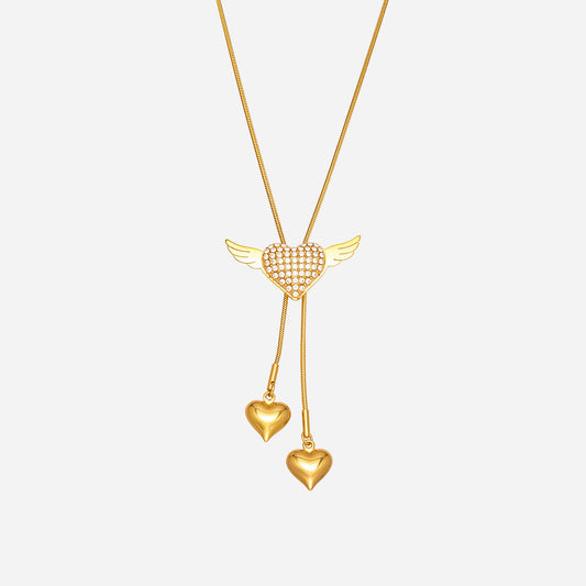 Winged puffy heart necklace in 18K gold plated stainless steel with CZ angel heart and double tassel hearts on a snake chain.